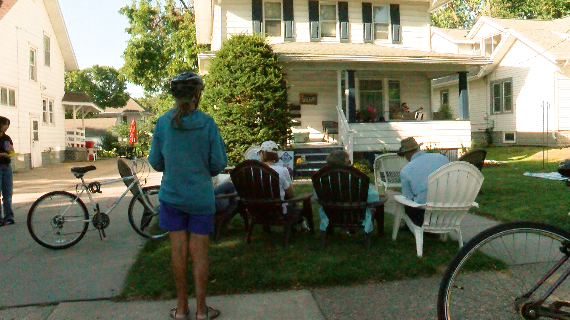 People gather on a front lawn for a porch performance in Rochester’s Kutzky Park neighborhood.